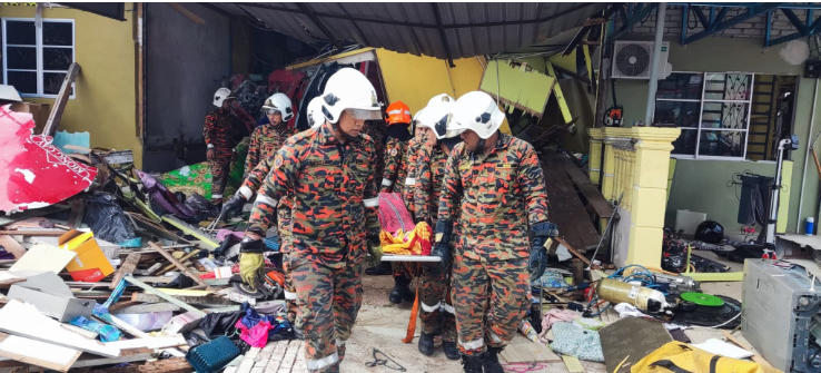 Anggota bomba mengeluarkan jenazah mangsa dari runtuhan rumah pada hari Sabtu.