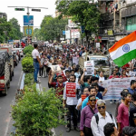 Kumpulan doktor berarak sambil mengibarkan bendera kebangsaan semasa menyertai demonstrasi di Kolkata.