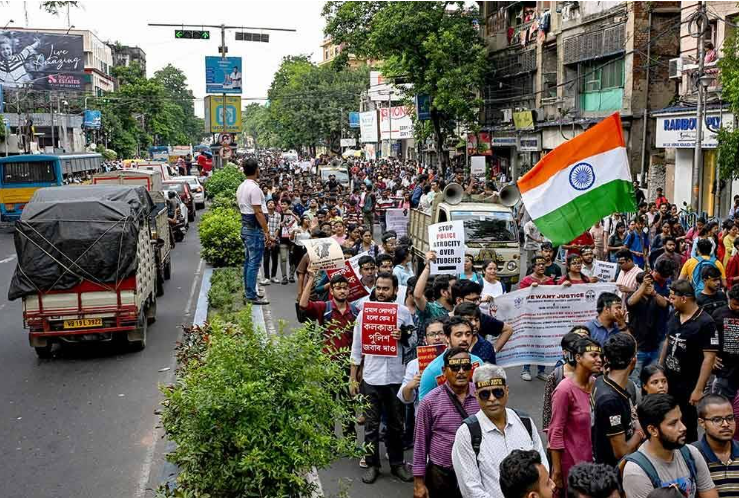 Kumpulan doktor berarak sambil mengibarkan bendera kebangsaan semasa menyertai demonstrasi di Kolkata.